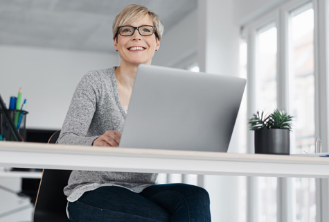 Low angle view of businesswoman sitting working at a laptop computer shutterstock 1769139350 475x320px