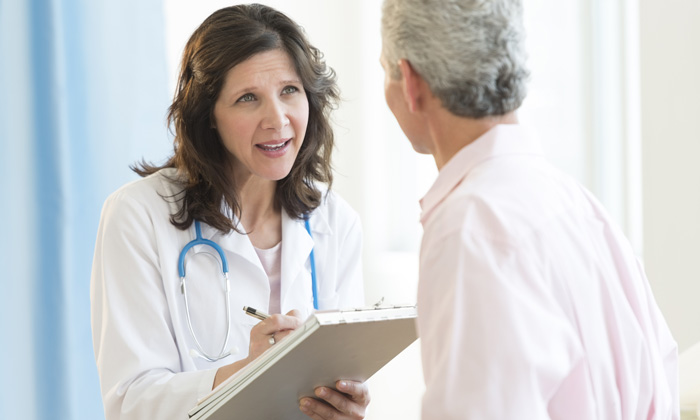 Mature female doctor discussing with patient in hospital shutterstock 147933542 700215420