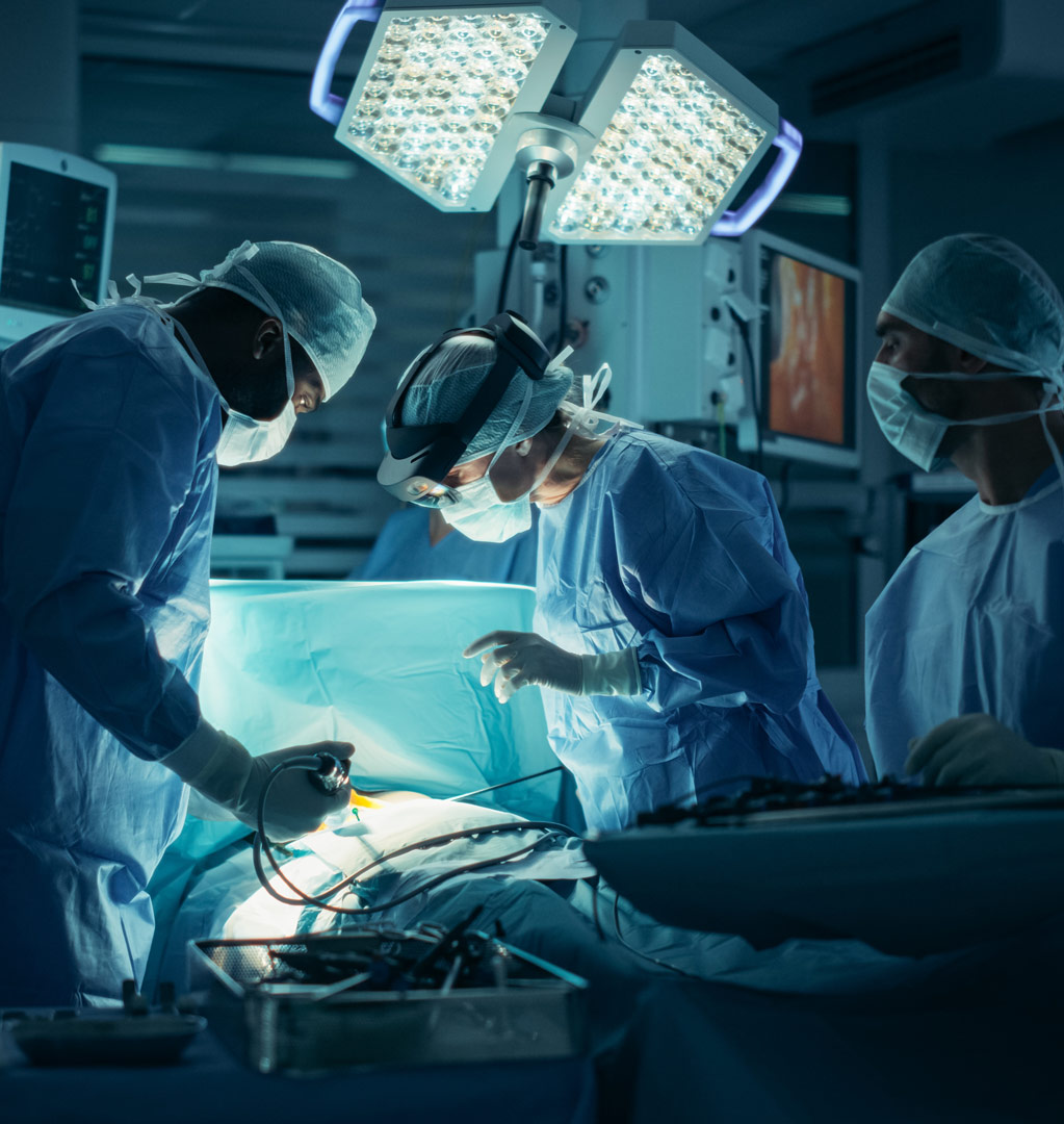 Three surgeons operating in a dark operating room