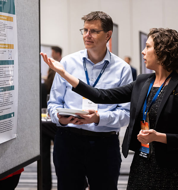 Two people looking at a large research poster at ABMS Conference