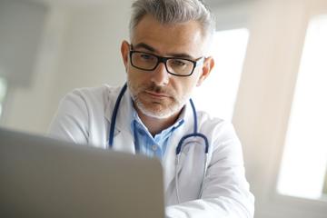 male doctor in an office working on patient file